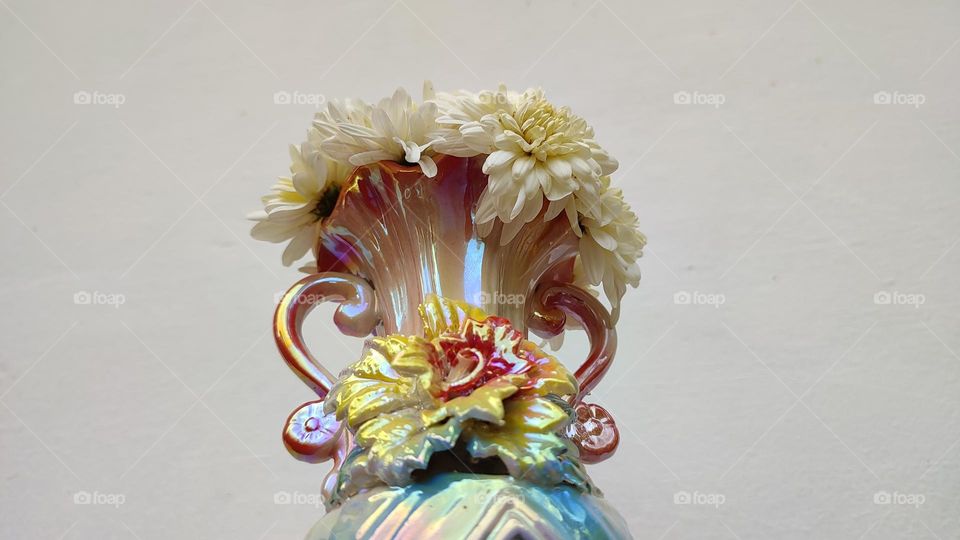 Beautiful white flowers in a colourful flowerpot with a flower sculpture, Flowers in a vase, colourful vase, white flowers in a vase