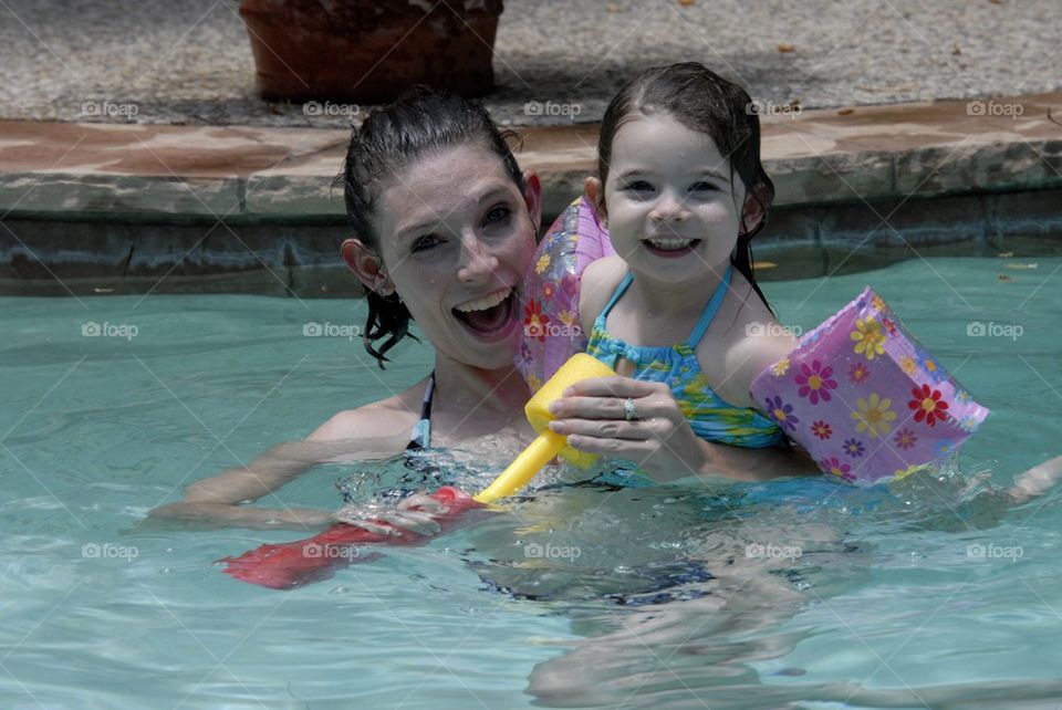 Mother and daughter in pool laughing