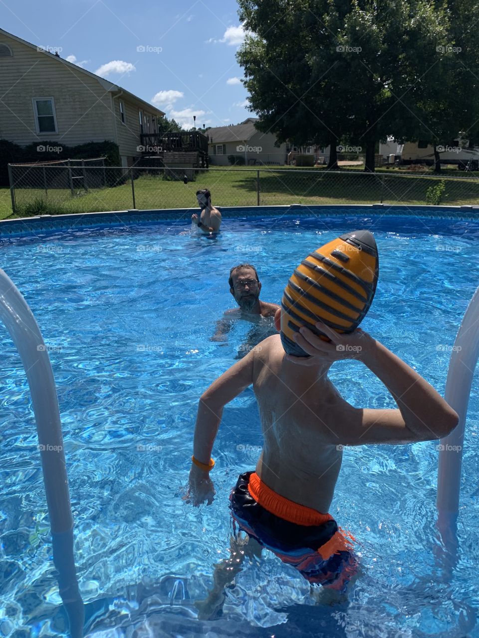 Football in the pool with dad and grandpa 