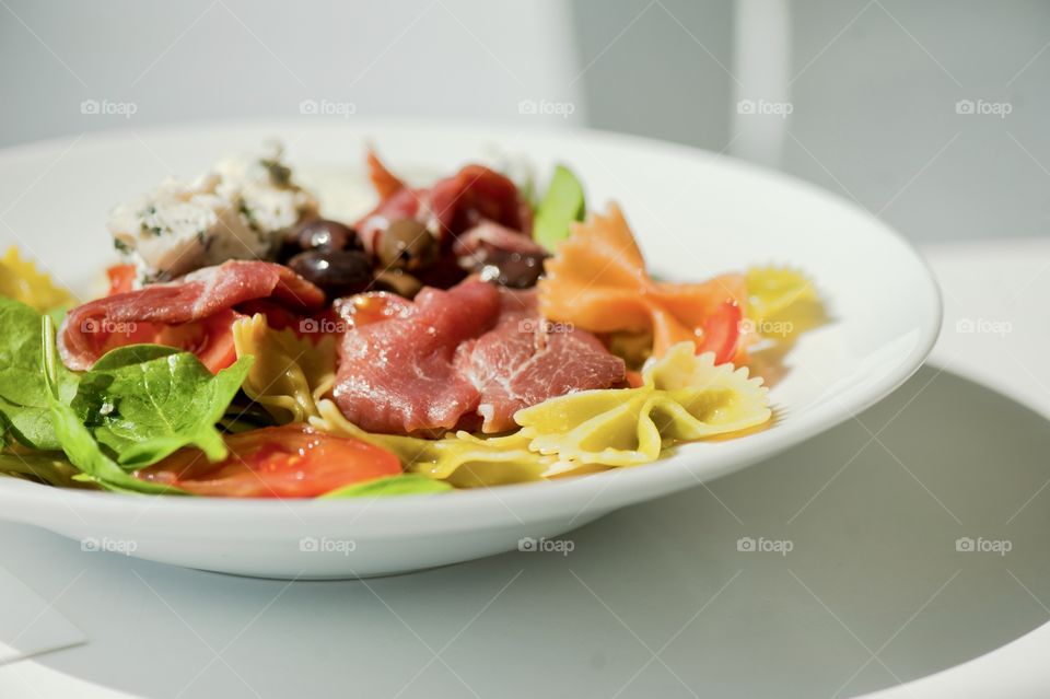 close-up of a young man eating a salad in a light kitchen