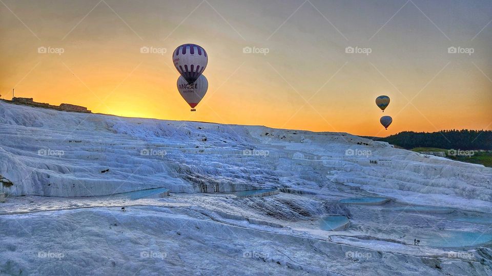 hot air balloons over the travertine cascading pools of Pumalakke Turkiye