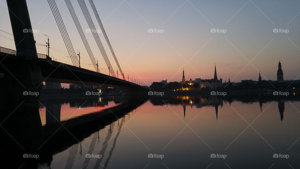 A beautiful sunset over city panorama with river and bridge in Riga, Latvia