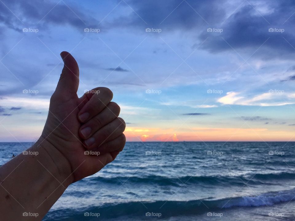 Hand doing thumbs up on the beach, Hollywood, FL, 