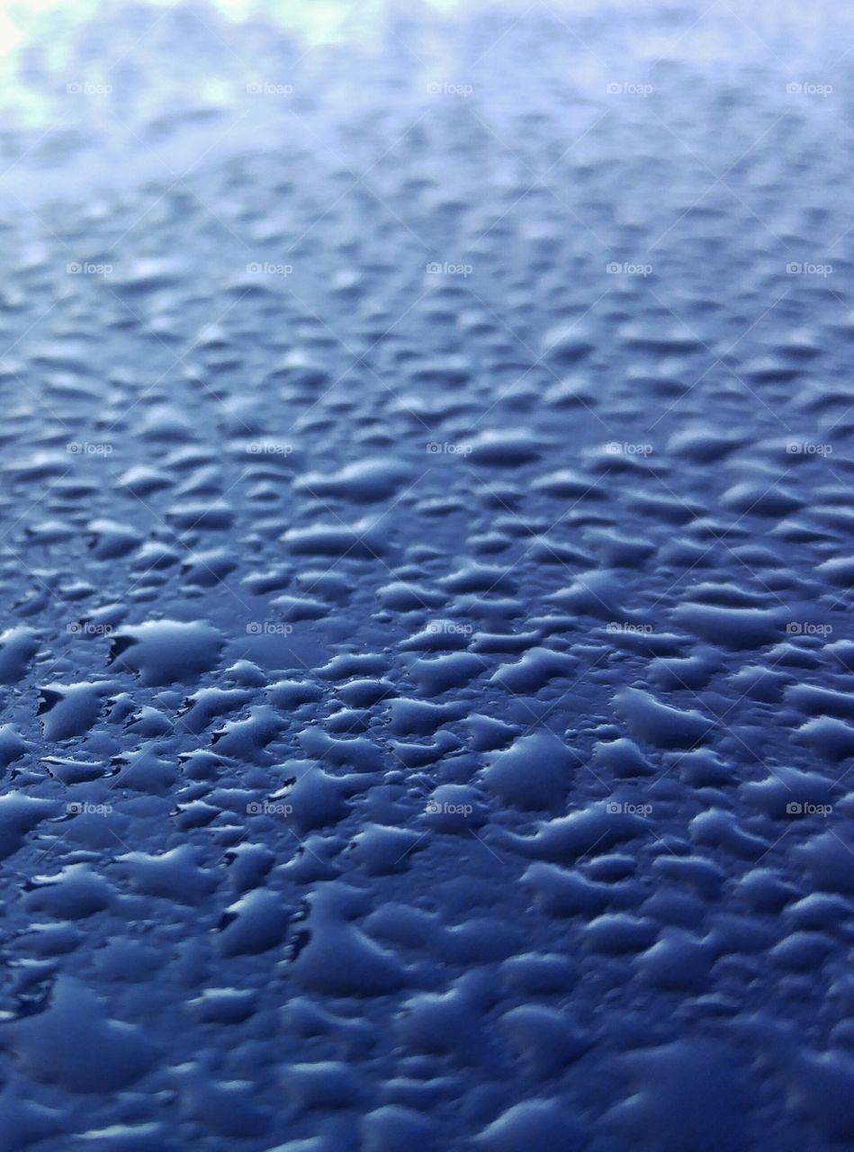 Morning dew on blue metal surface