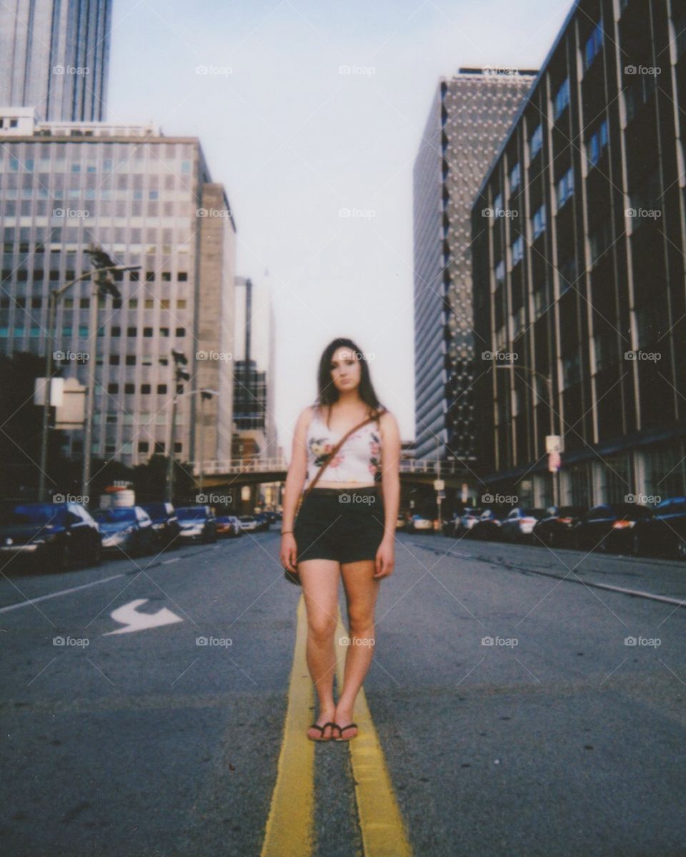 City girl stands in road.

