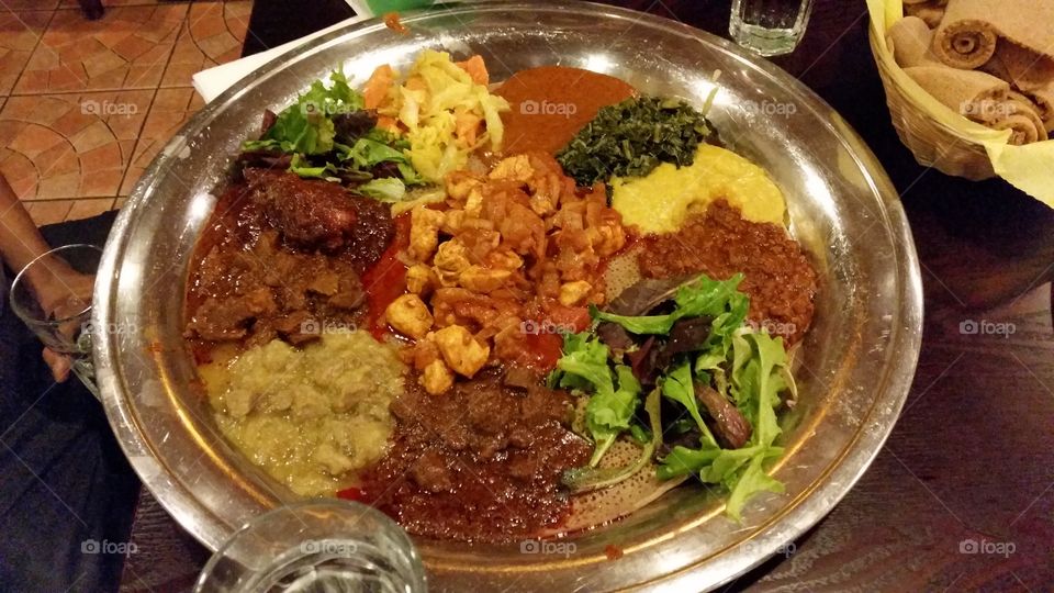 Ethopian plate, lamb and chicken stew with lentils and greens