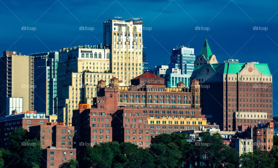 Sunset Over Brilliant Brooklyn New York from the East River - Shadowy and Golden Sunset over Brooklyn with all the intricate and classic architecture.