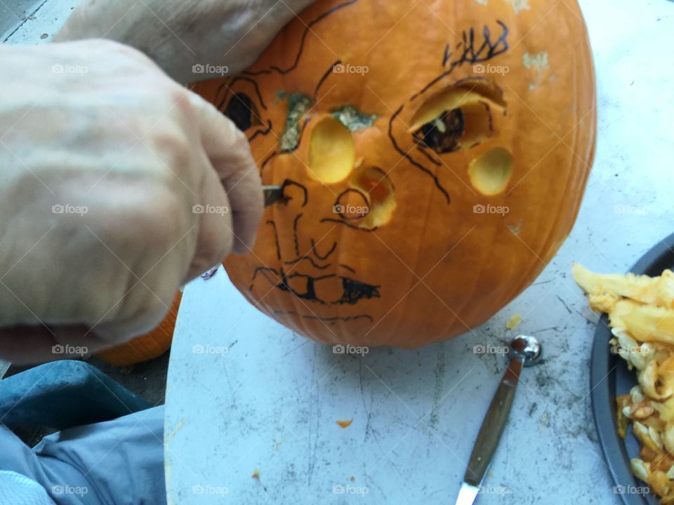 Man carves Halloween pumpkin 