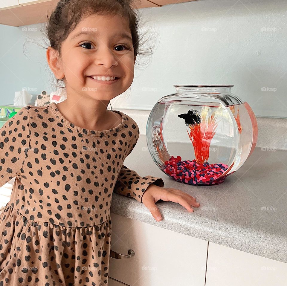 Little girl excited to get a fish, happy about her pet fish, little girl smiles with fish, happy to have a pet 