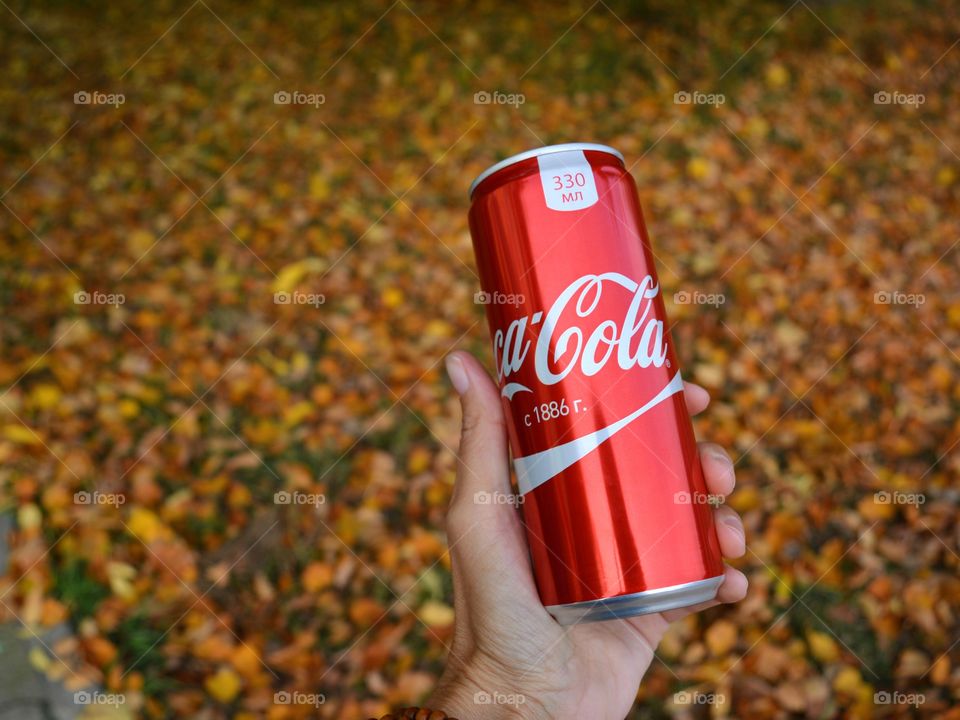 coca cola in the hand fall beautiful texture background