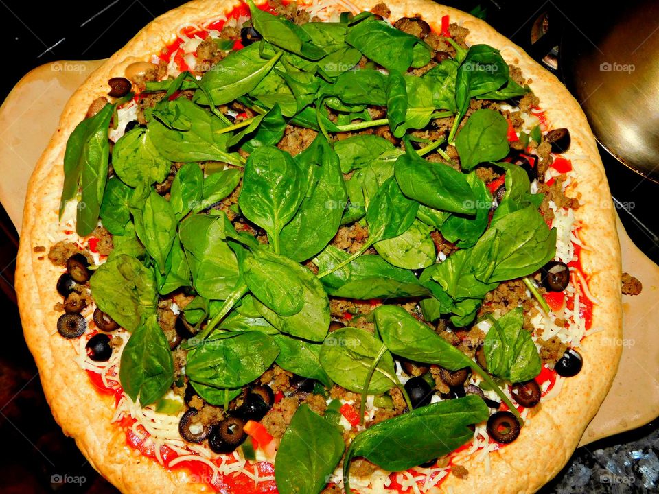 Cook the pizza twice. First, cook the premade dough “naked” without any toppings. On the second trip to the oven, add all the ingredients and cook the pizza until the cheese melts and the crust is golden brown. Brush perimeter with olive oil