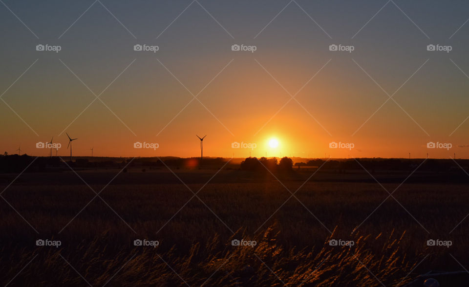 solnedgång bakom vindkraftverken