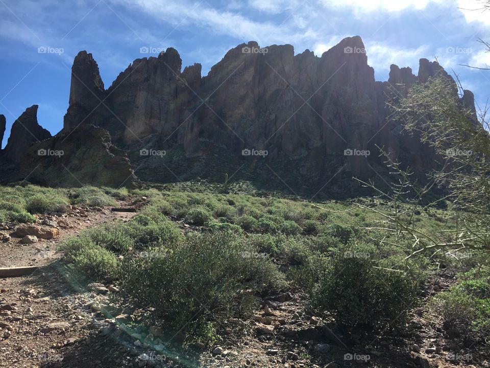 Desert rock mountain, green brush and blue skies