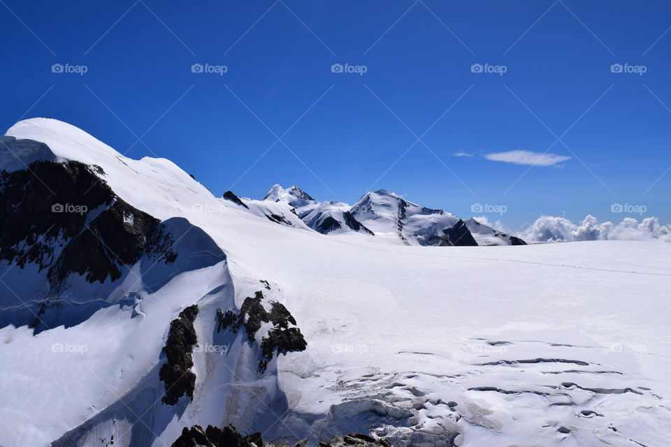 Swiss Alps with tiny people skiing