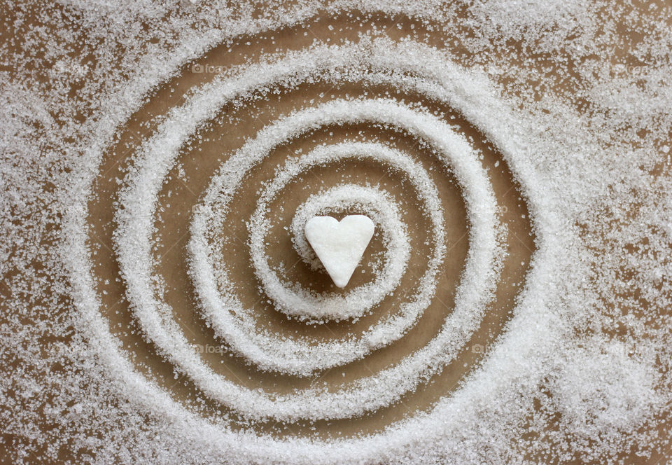 Heart shape sugar cube and sugar spiral on the table