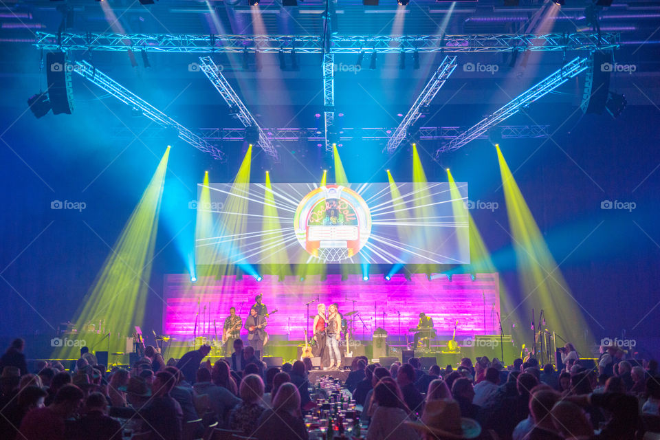 A large corporate event with live performers and various appearances in a large arena.