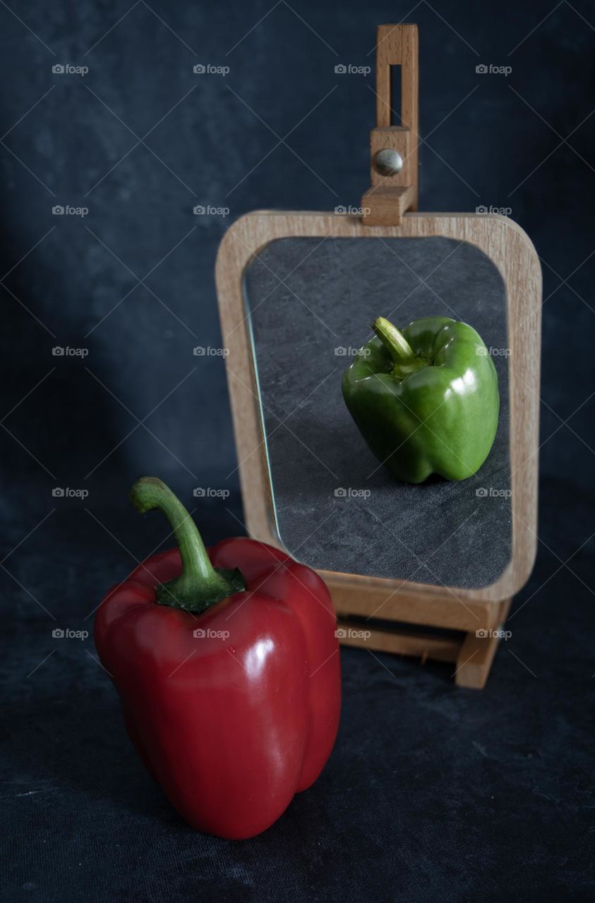 abstraction minimalism philosophy, red bell pepper looks in the mirror and sees green pepper in reflection
