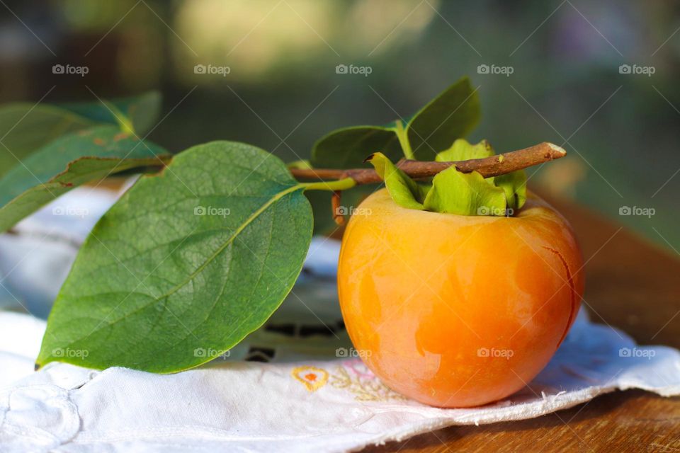 Close up of a ripe organic Kaki Japanese Persimmon.  Beautiful sweet, healthy and refreshing dessert