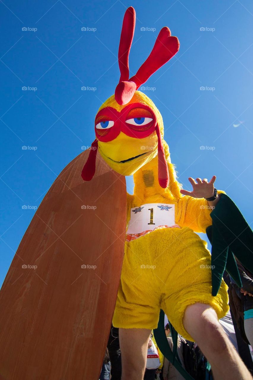 person dressed in a large yellow chicken costume during a race