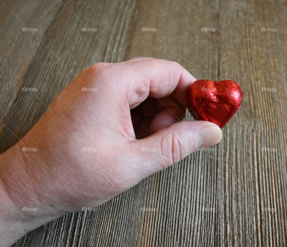 Hand holding heart shaped candy