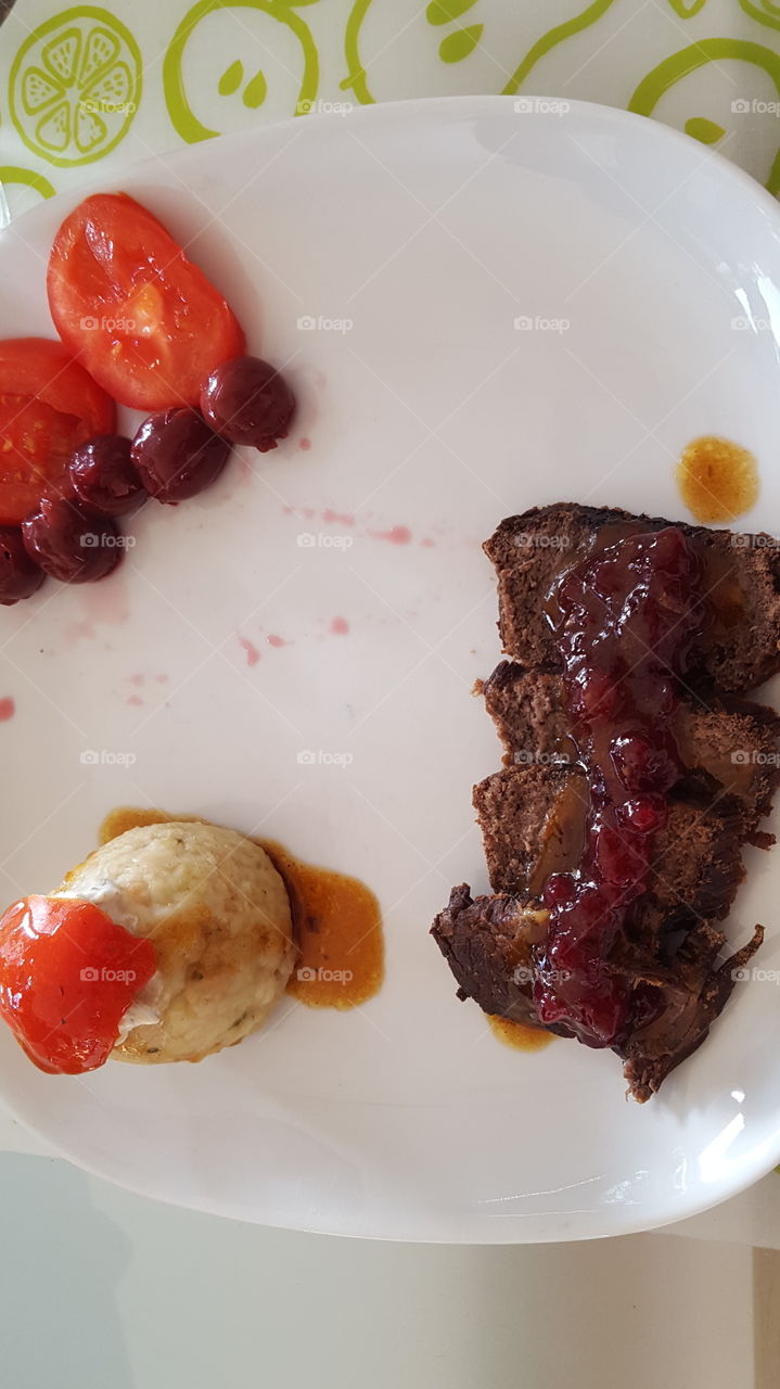 Sauerbraten mit Klöße und Tomaten und Kirschen