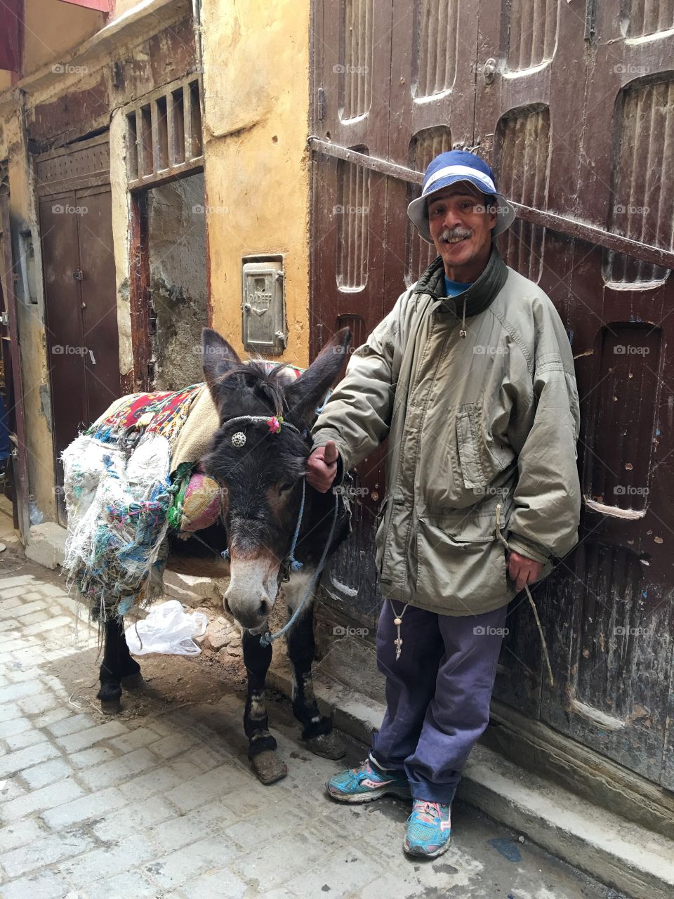 Man with thump up and standing near donkey