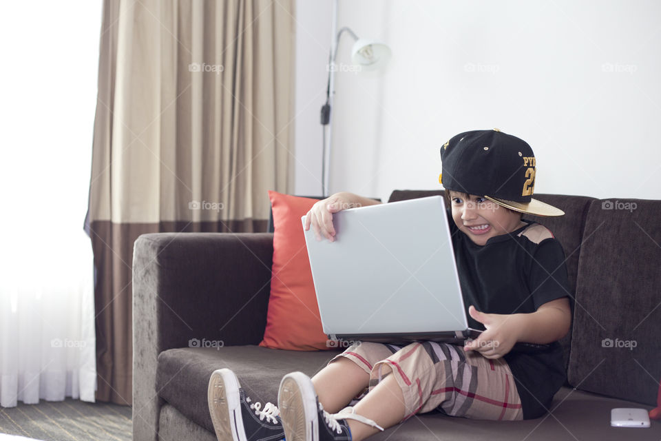 young kid acting as busy business man working home  with laptop
