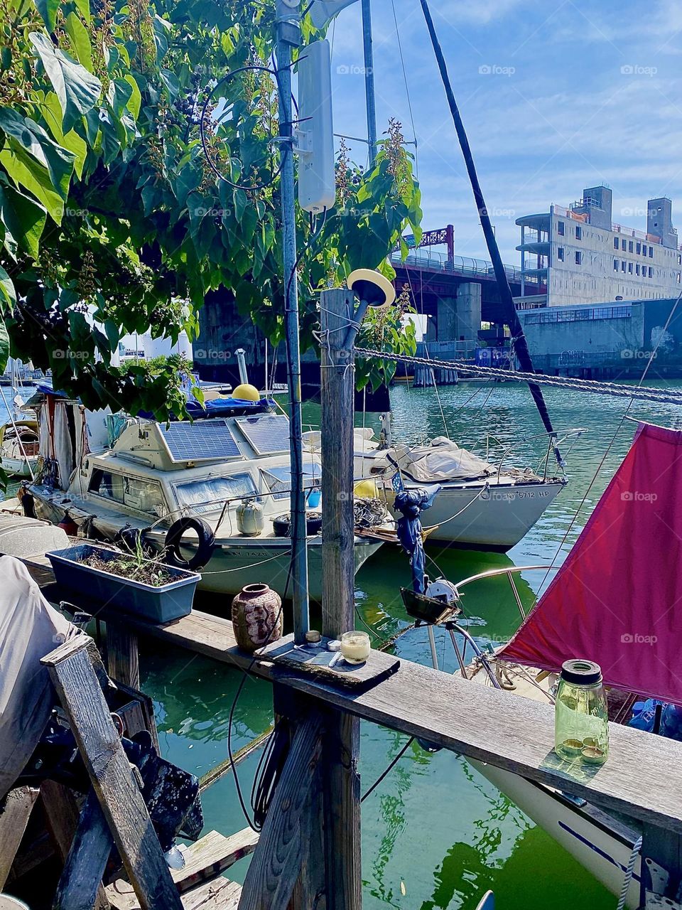 This is a spectacular view of the boats at “Newtown Creek” by the “Pulaski Bridge” seen from the wooden handcrafted terrace built on the LIC shore on a warm, bright and sunny afternoon in September 2023. Hypnotic Productions