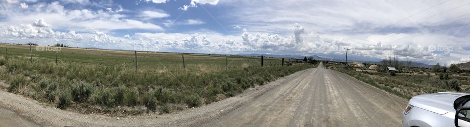 Cloudy with some blue skies. The grass the dirt road the fence if you love the country side this is an amazing view. 