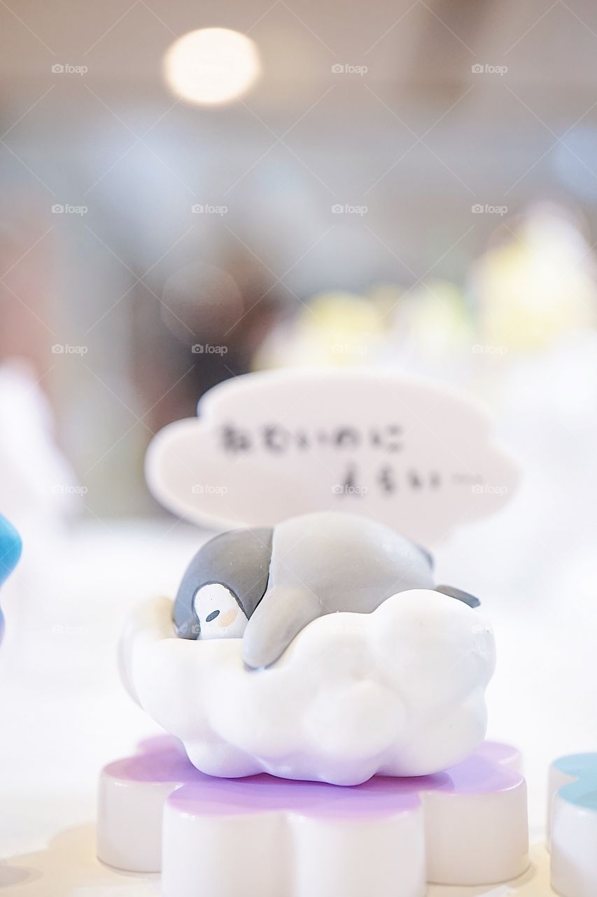 Penguin toy. A baby penguin plastic toy is having a sweet dream sleeping on the cotton cloud. Good night concept.