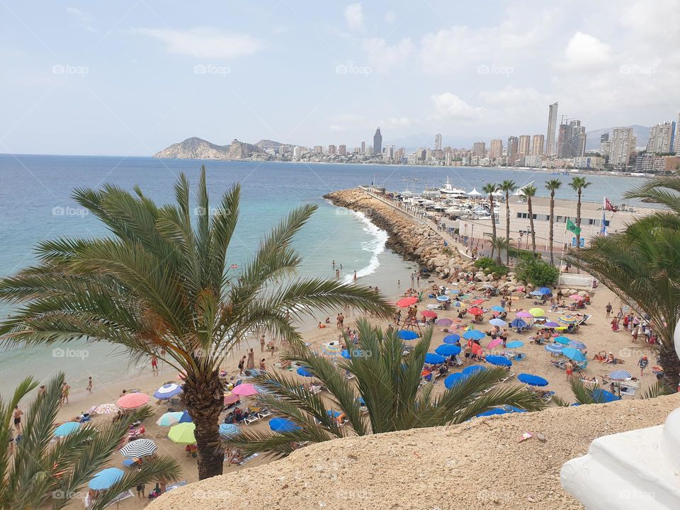 beautiful Benidorm beach with its colorful umbrellas and visitors enjoying its beauty