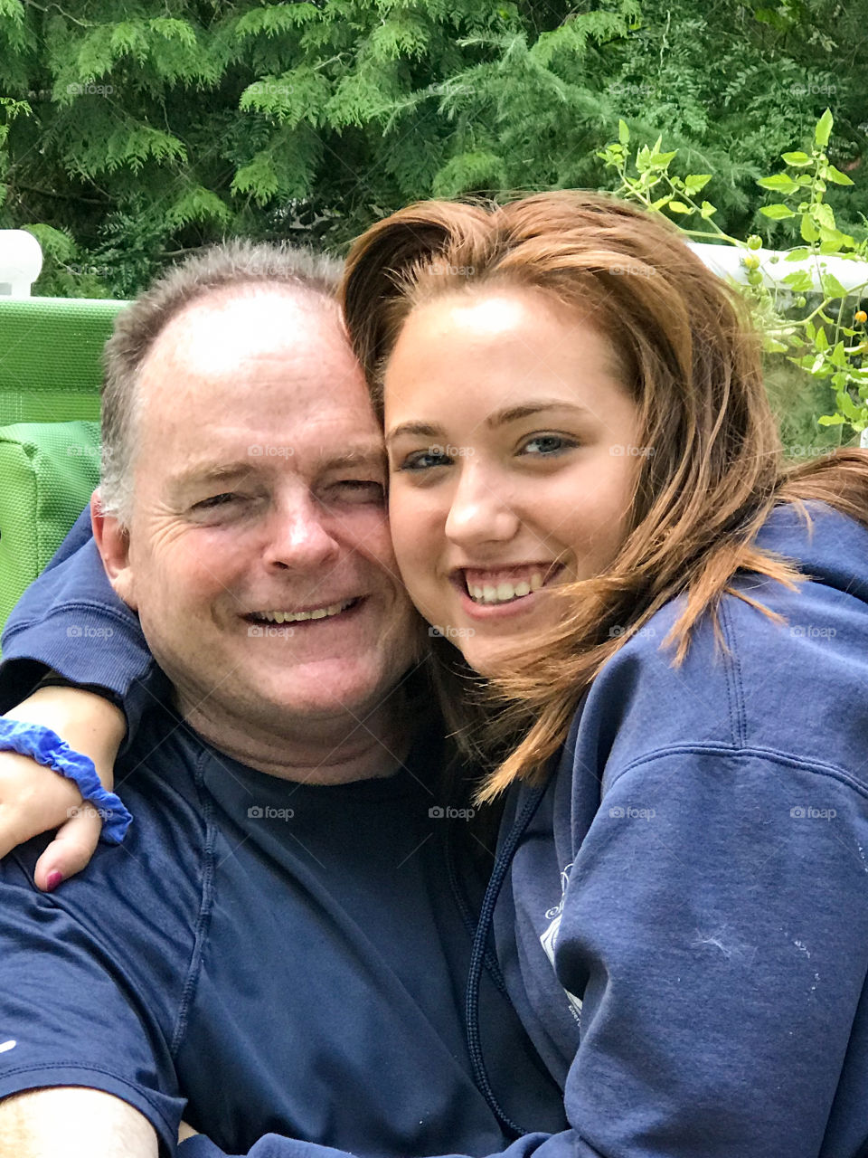 Smiles of my happy family! Big smiles of my husband and daughter while we were relaxing on our deck listening to the sounds of nature in the woods behind our house. 