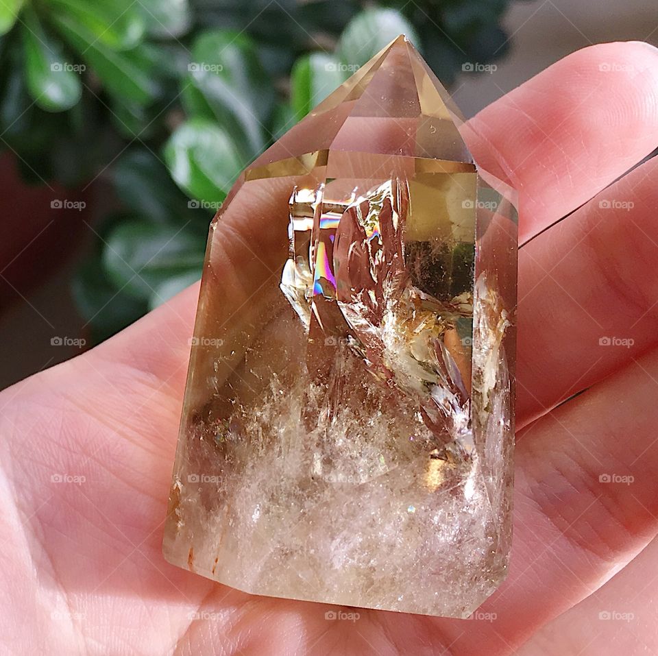 A polished yellow citrine quartz crystal tower point.