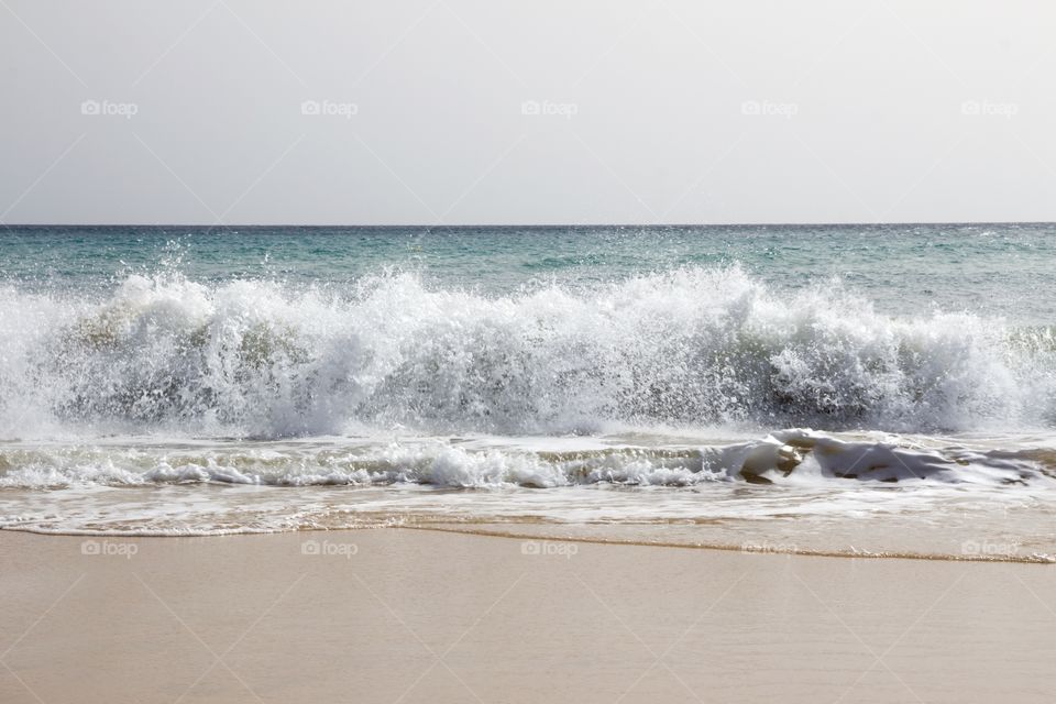 Beautiful sandy beach with waves on a sunny day on vacation in Fuerteventura, Canary Islands - fin Sandstrand med höga vågor på Kanarieöarna , semester
