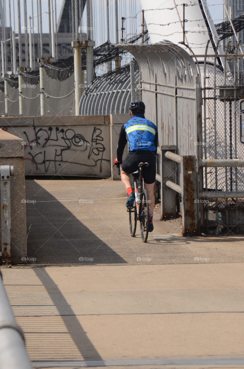 A bicyclists rides his bike over the George Washington bridge for some daily exercise.