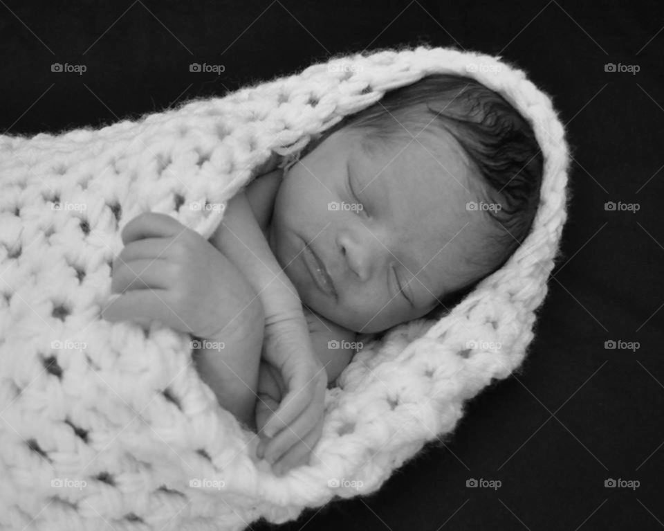 newborn. tiny newborn wrapped in  crocheted cocoon