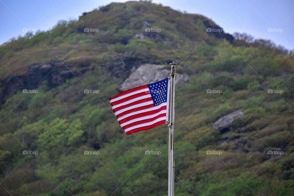 American flag standing tall over a mountain