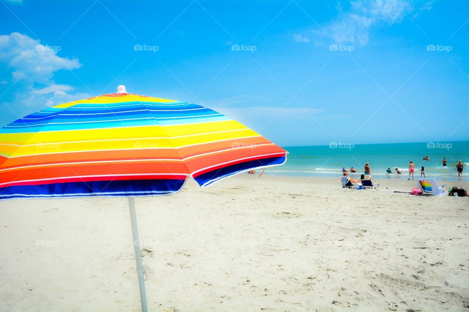 Summer day. A pretty beach umbrella at the seashore.