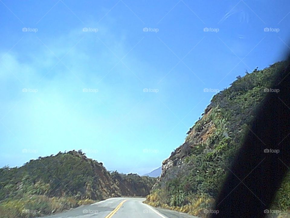 Road by mountains approaching a bend