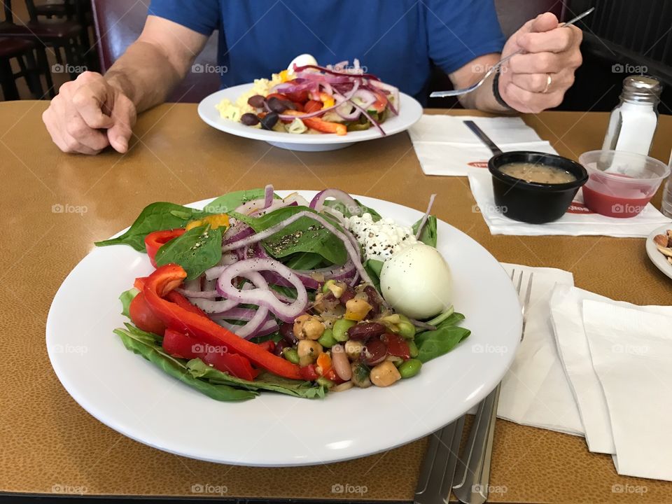 Eating a healthy salad of greens and beans and sweet red peppers.