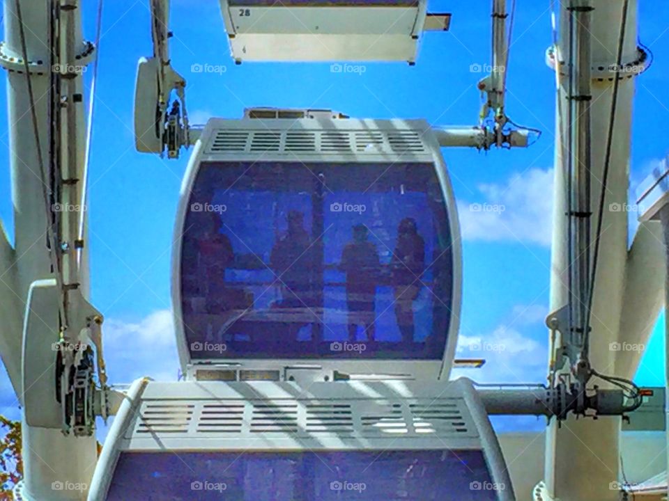Silhouettes of people riding on the Orlando Eye Ferris wheel 
