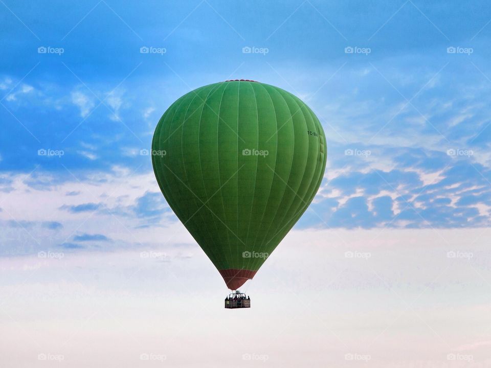 Green hot air balloon. Green hot air balloon floating in the air in Cappadocia, Turkey
