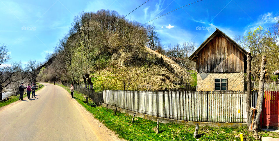 Old house in the countryside. Picture of a road passing by an old house and thru a forest in a Romanian countryside 