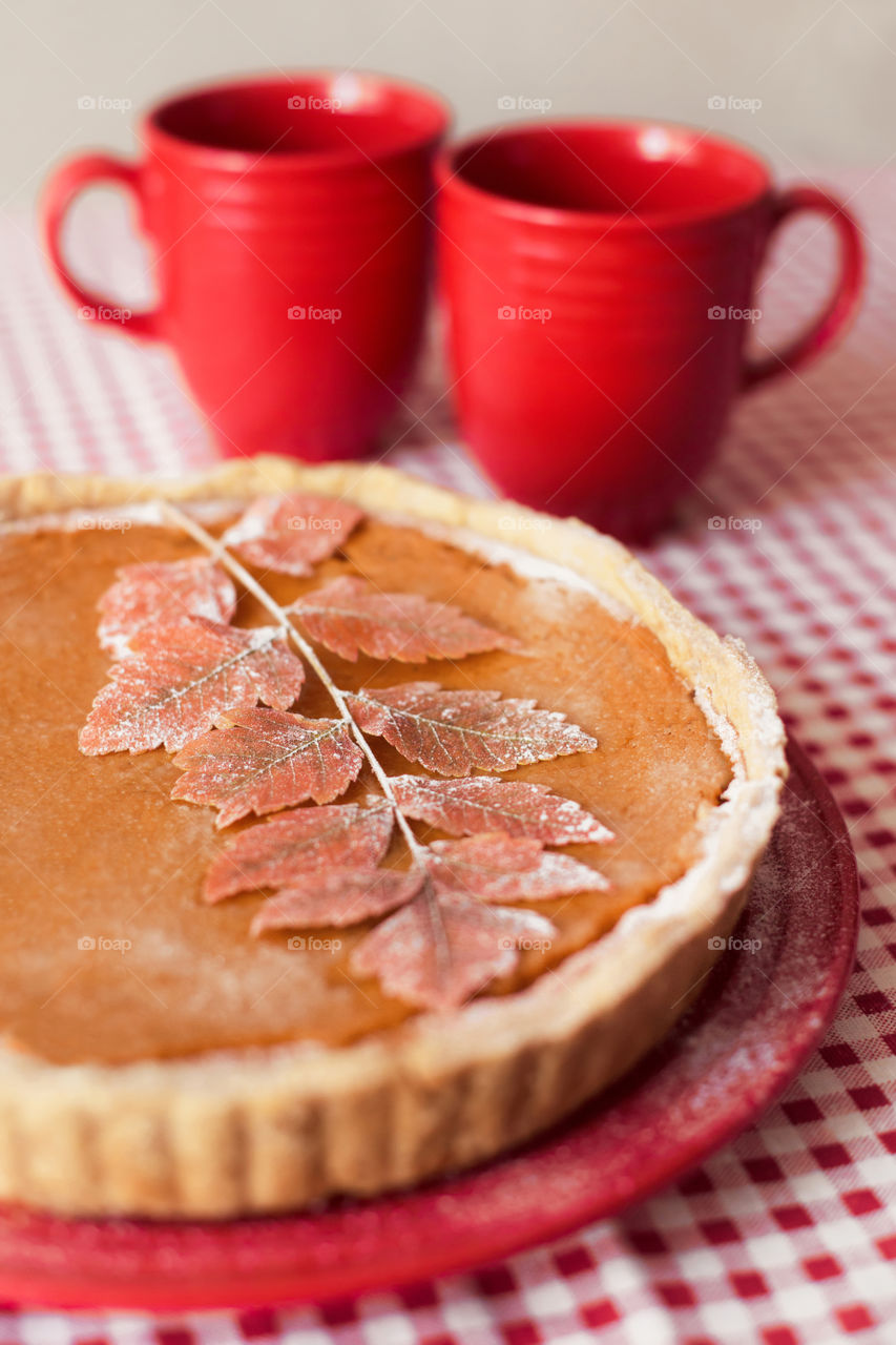 American pumpkin pie with two cup of warm drinks 