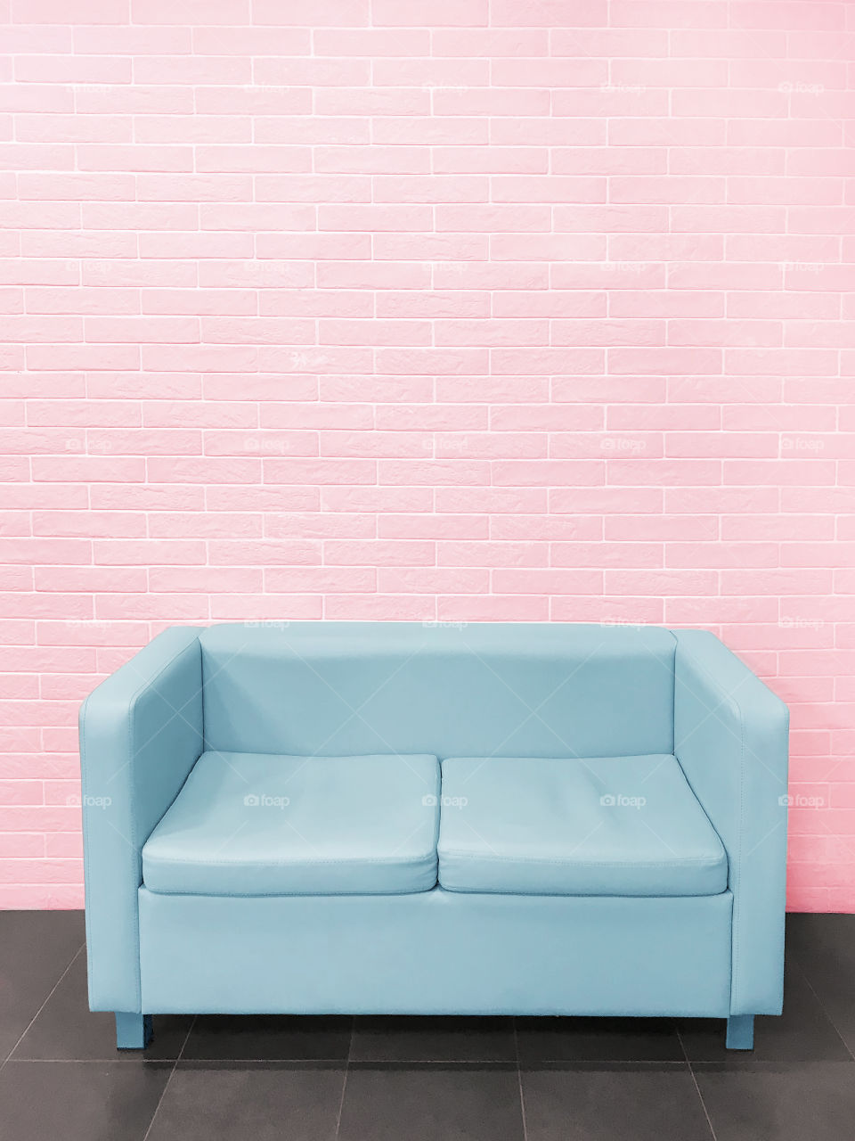 Blue sofa on pink brick wall background 