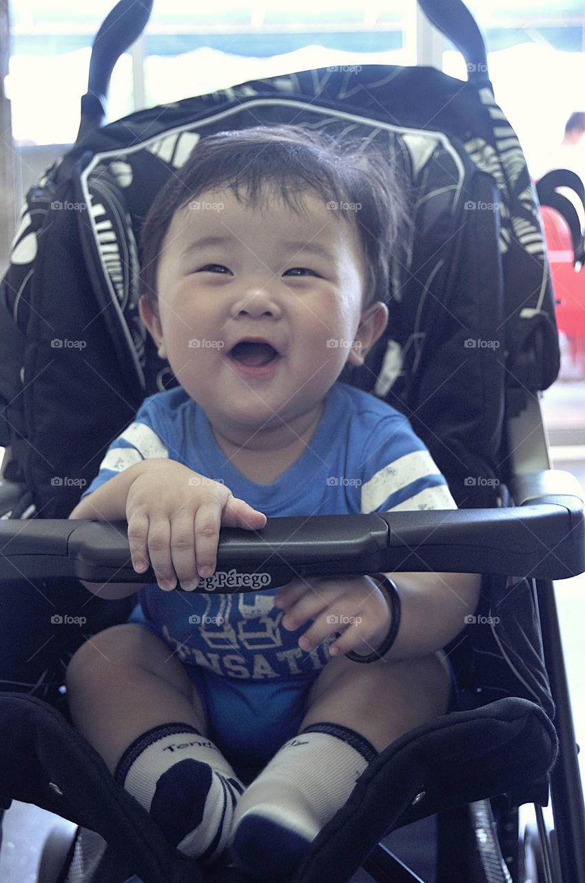 Close-up of Asian boy sitting in stroller