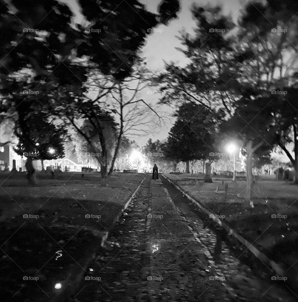 Cloaked figure in graveyard spooky Halloween 