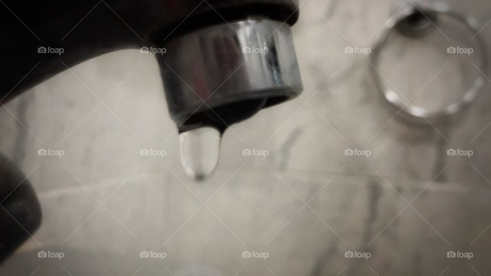 Water Drop... A faucet that is barely closed, dripping, wasting water... But still, a fascinating sign to observe.
