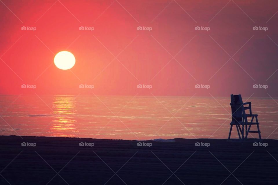 Guard Chair. Lone lifeguard chair on the beach at dawn. 