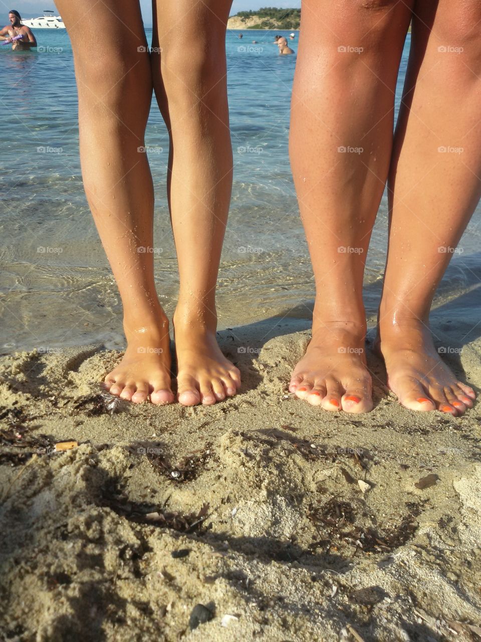 Kid and woman feet on a beach